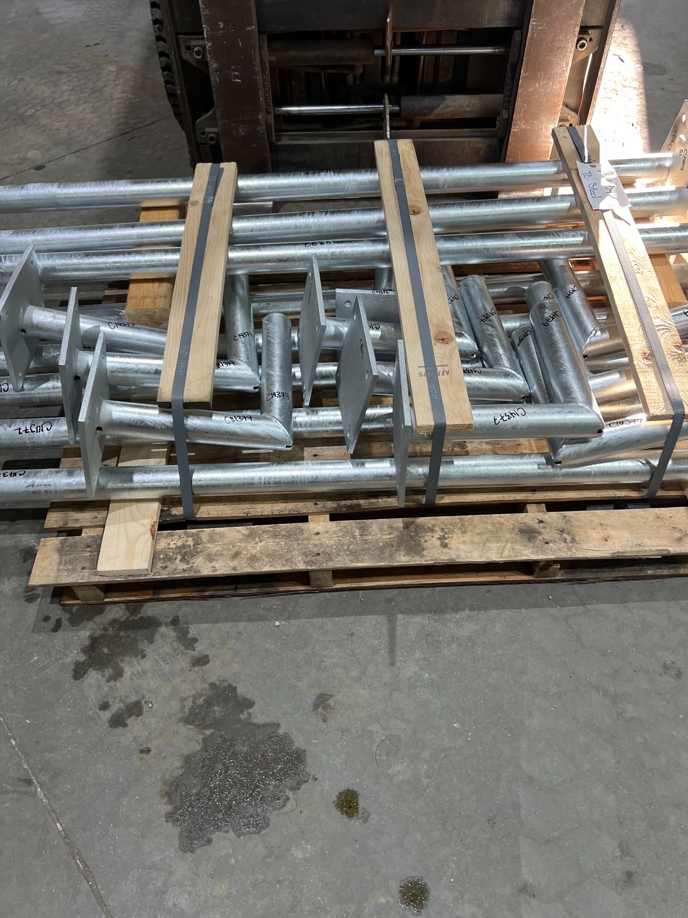 Instrument stand posts, mounting arms and drilled base plates on a pallet