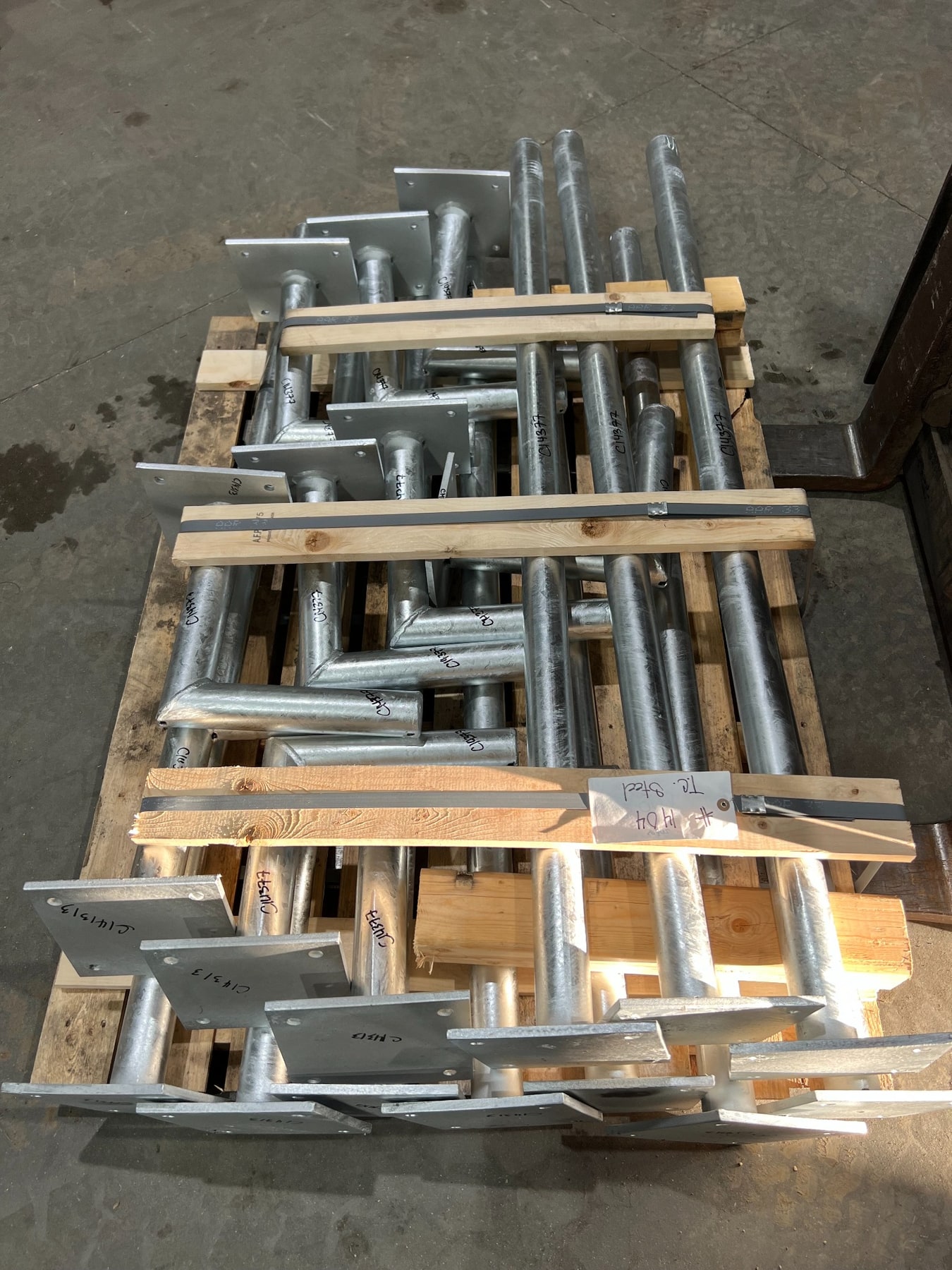 Completed instrument stands with identification markings strapped to a shipping pallet